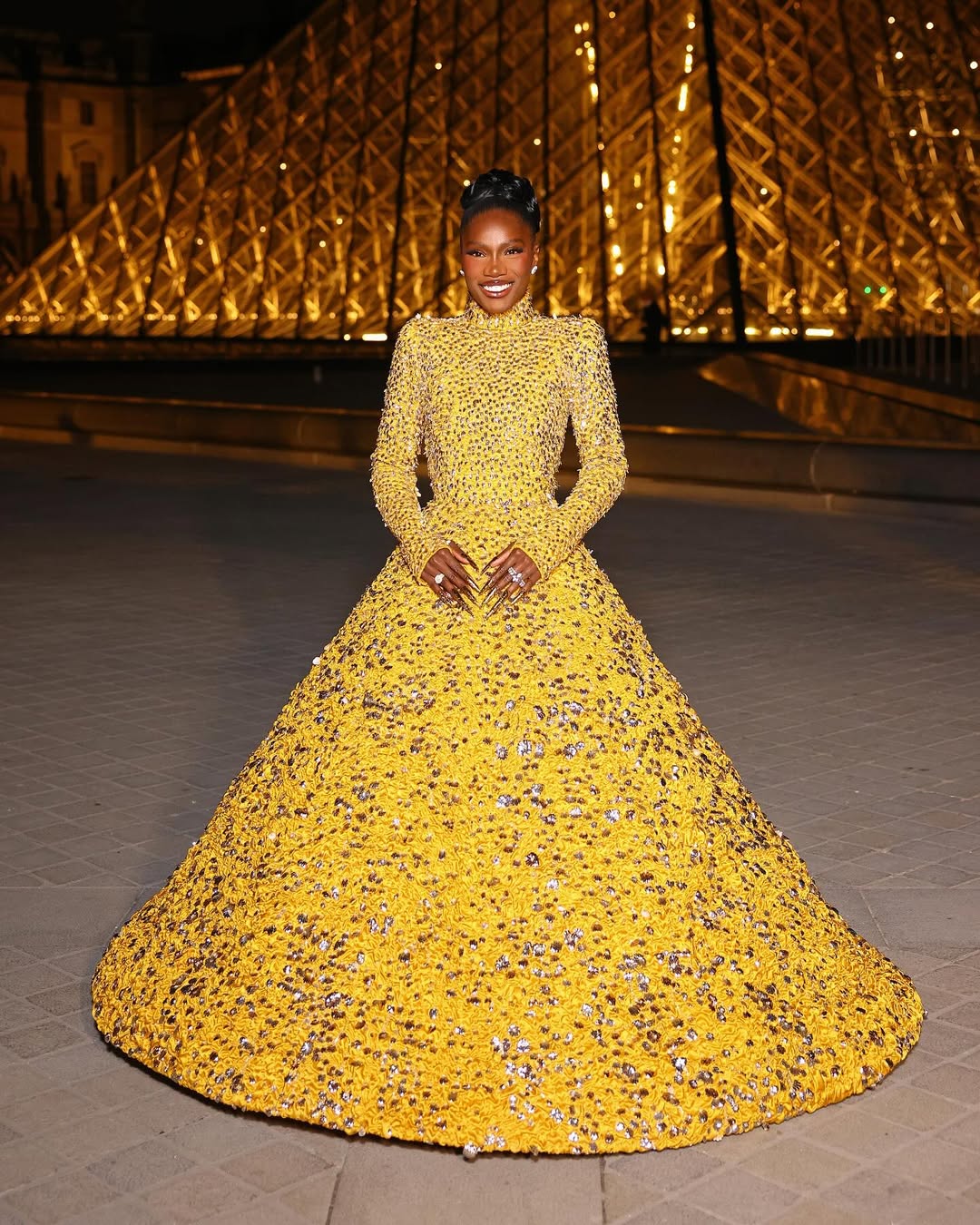 Doechhi wears gold Valentino princess gown at the Louvre's Grand Dinner.